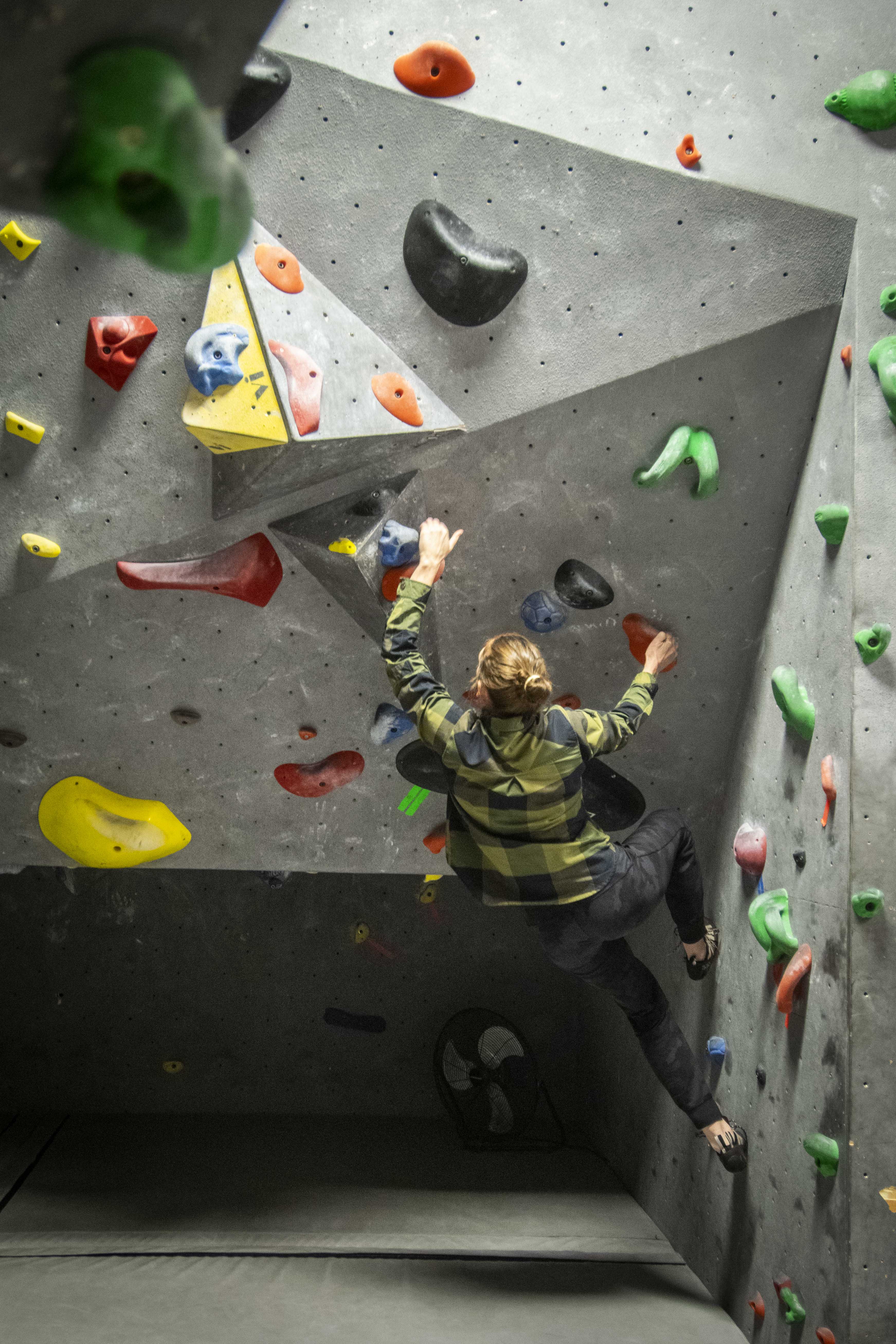 A climber on Top Out's bouldering wall